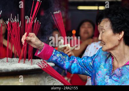 Jakarta, Indonésie - 28 janvier 2017 : une vieille femme chinoise met de l'encens Banque D'Images