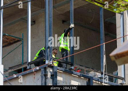 Moscou, Russie. 30 juin 2023. Les ouvriers masculins de la construction installent le cadre en fer pour le vitrage du bâtiment. Banque D'Images