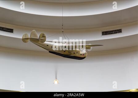 Un modèle de « Yankee Clipper » du système de la compagnie aérienne panaméricaine est suspendu à la lucarne du terminal aérien marin de l'aéroport LaGuardia, au-dessus du « vol » mural. Banque D'Images