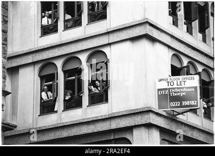 Les employés de bureau regardent bon Jovi jouer un concert de bus gratuit sur le kiosque de Queen Street, Cardiff, pays de Galles, Royaume-Uni le 21 juin 1995. Le concert était de faire connaître le concert peu vendu au stade Arms Park le lendemain. Photo : Rob Watkins Banque D'Images