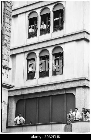 Les employés de bureau regardent bon Jovi jouer un concert de bus gratuit sur le kiosque de Queen Street, Cardiff, pays de Galles, Royaume-Uni le 21 juin 1995. Le concert était de faire connaître le concert peu vendu au stade Arms Park le lendemain. Photo : Rob Watkins Banque D'Images