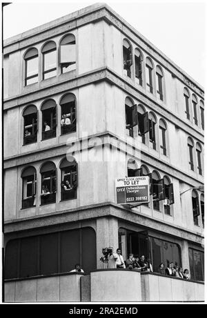 Les employés de bureau regardent bon Jovi jouer un concert de bus gratuit sur le kiosque de Queen Street, Cardiff, pays de Galles, Royaume-Uni le 21 juin 1995. Le concert était de faire connaître le concert peu vendu au stade Arms Park le lendemain. Photo : Rob Watkins Banque D'Images