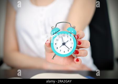 Femme tenant l'horloge dans la main Banque D'Images