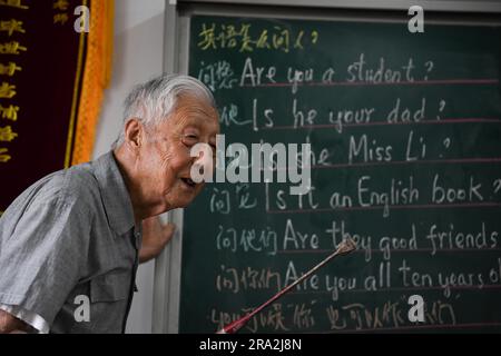 HEXIAN, 30 juin 2023 (Xinhua) -- Ye Lianping donne une classe d'anglais à la 'maison pour les enfants laissés-pour-compte' dans le village de Buchen du comté d'Hexian, dans la province d'Anhui, en Chine orientale, à 29 juin 2023. YE Lianping, 95 ans, enseignant à la retraite, a commencé à donner des cours d'anglais gratuits en 2000 lorsqu'il a créé une « maison pour les enfants laissés pour compte » dans le village de Buchen. La plupart de ses élèves sont laissés dans le village alors que leurs parents sont allés travailler dans les villes. Au cours des 23 dernières années, plus de 2 000 enfants ont bénéficié des classes de Ye. YE Lianping, vivant une vie simple sans enfants, passe la plupart de son savi Banque D'Images