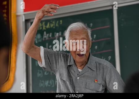 HEXIAN, 30 juin 2023 (Xinhua) -- Ye Lianping donne une classe d'anglais à la 'maison pour les enfants laissés-pour-compte' dans le village de Buchen du comté d'Hexian, dans la province d'Anhui, en Chine orientale, à 29 juin 2023. YE Lianping, 95 ans, enseignant à la retraite, a commencé à donner des cours d'anglais gratuits en 2000 lorsqu'il a créé une « maison pour les enfants laissés pour compte » dans le village de Buchen. La plupart de ses élèves sont laissés dans le village alors que leurs parents sont allés travailler dans les villes. Au cours des 23 dernières années, plus de 2 000 enfants ont bénéficié des classes de Ye. YE Lianping, vivant une vie simple sans enfants, passe la plupart de son savi Banque D'Images