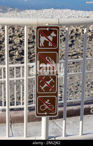 Un panneau de plage en bois avec des lettres blanches affichant des articles interdits Banque D'Images