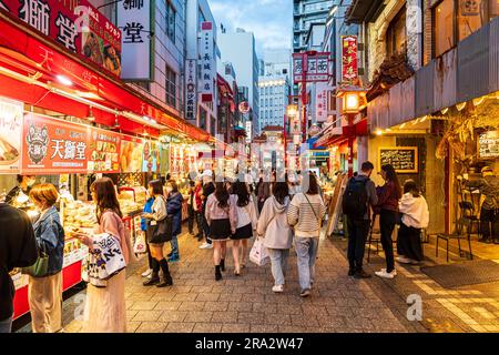 Chinatown à Kobe la nuit. Vue sur une petite rue piétonne remplie de gens qui erraient entre les stands de nourriture vendant la cuisine chinoise à emporter. Banque D'Images