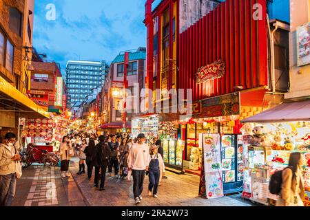 Chinatown à Kobe la nuit. Vue sur une petite rue piétonne remplie de gens qui erraient entre les stands de nourriture vendant la cuisine chinoise à emporter. Banque D'Images