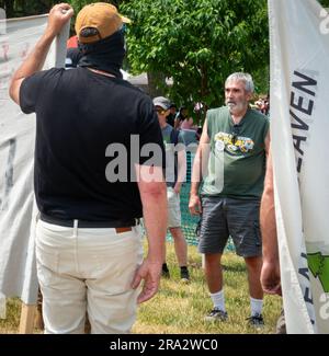 HUDSON, WI, États-Unis - 17 JUIN 2023 : manifestants anti LGBTQ+ masqués non identifiés et participants au festival lors de la célébration de la fierté d'Hudson. Banque D'Images