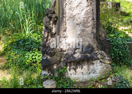 Détail d'une tombe au cimetière Elias à Dresde avec un ange de deuil et un serpent représentant l'infini. Le cimetière Elias de Dresde est désaffecté depuis 1876 et fermé depuis 1924. Des traces des bombes incendiaires de la Seconde Guerre mondiale sont encore visibles sur certaines pierres tombales Banque D'Images