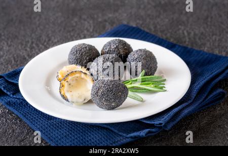 Boules de mozzarella panées avec truffe noire sur l'assiette Banque D'Images