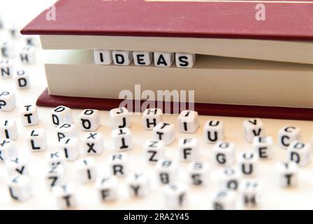 Idées de mots écrites avec des lettres entre les pages d'un livre fond blanc avec des lettres réparties autour du concept de lecture d'éducation Banque D'Images