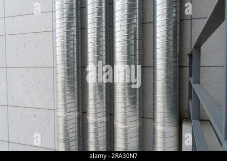 Tubes de ventilation qui montent jusqu'au toit sur le mur extérieur d'une tour de bâtiment Banque D'Images