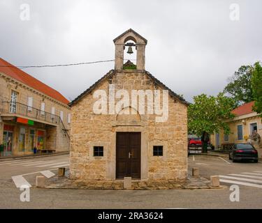 Le front de l'église des Saints Michael, Pierre et Paul à Nerezisca, île de Brac, Croatie. Célèbre pour l'arbre Brac Bonsai, un pin qui pousse du toit Banque D'Images