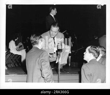 Photographie de Bob Hope qui s'accroupite et parle au public au NBC microphone. Banque D'Images