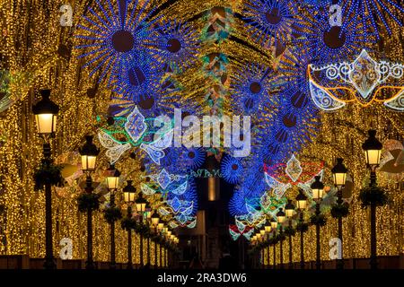 Un fond coloré et festif pendant le carnaval à Malaga Espagne avec des lumières de la ville, des masques de carnaval et une atmosphère calme lorsque les défilés se terminent Banque D'Images