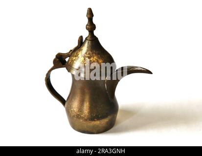 cafetière arabe (dallah) figurine miniature en laiton sur fond blanc vintage usé théière en cuivre patiné Banque D'Images