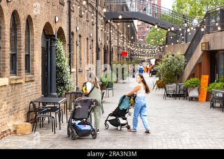 Femme avec poussettes Coal Drops Yard Shopping Complex partie de Kings Cross Central, Londres développement a été conçu par Thomas Heatherwick Banque D'Images