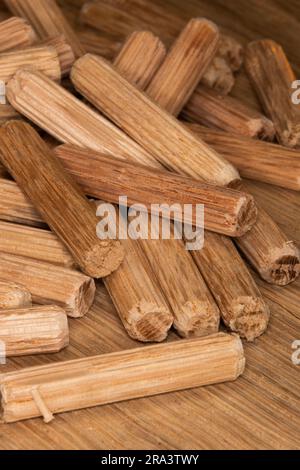 pile de chevilles en chêne sur fond de chêne, chevilles utilisées pour joindre deux morceaux de bois, joint, menuiserie Banque D'Images