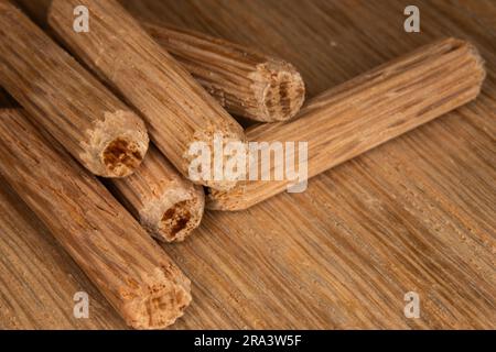 pile de chevilles en chêne sur fond de chêne, chevilles utilisées pour joindre deux morceaux de bois, joint, menuiserie Banque D'Images