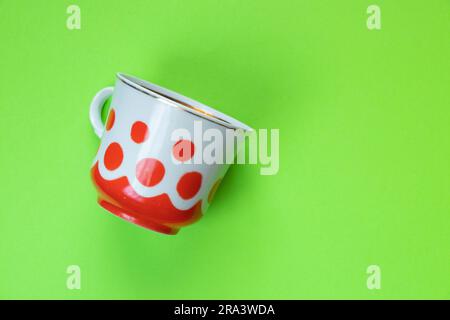 vieille tasse avec pois rouges sur fond rouge gros plan Banque D'Images