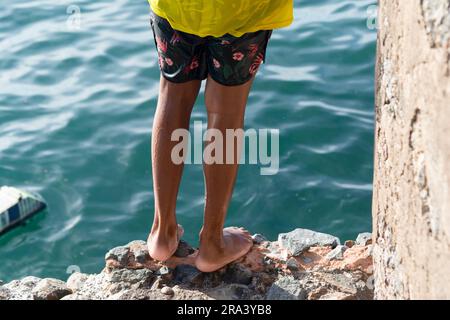 Salvador, Bahia, Brésil - 14 janvier 2022: Partie inférieure du corps d'un jeune homme sur le bord de la jetée du Musée d'Art moderne de Bahia à Salv Banque D'Images