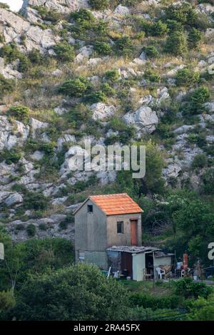 ancienne ferme croate située à flanc de montagne ou à flanc de colline avec toit en tuiles en terre cuite. Banque D'Images