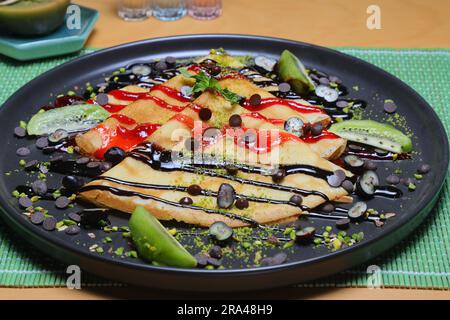 Crêpes fines maison avec tartinade au chocolat et noisettes pour le petit déjeuner ou le dessert. bannière, menu, place de recette pour le texte, vue de dessus. Banque D'Images