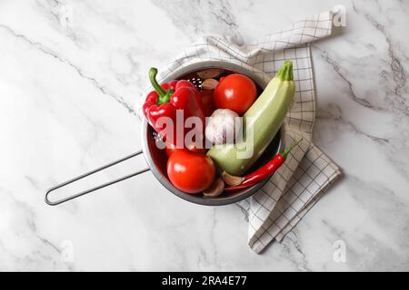 Légumes frais pour ratatouille en passoire sur table en marbre blanc, plat Banque D'Images