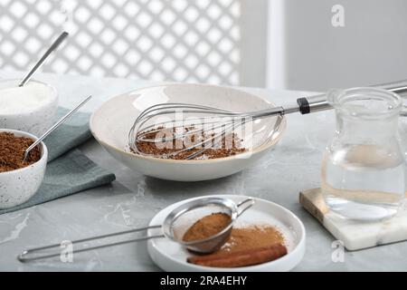 Faire du café de Dalgona. Granulés instantanés et poudre de cannelle sur table gris clair Banque D'Images