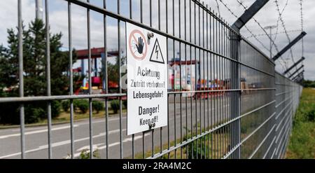 Hambourg, Allemagne. 30th juin 2023. Un panneau avec l'inscription 'attention, pas d'entrée! Danger de mort » est affiché sur la clôture extérieure du terminal à conteneurs Hamburg-Altenwerder. Il y a eu plusieurs pauses la nuit au cours des dernières nuits. Jusqu'à présent, environ 40 personnes ont été arrêtées sur le site portuaire clôturé. Credit: Markus Scholz/dpa/Alay Live News Banque D'Images