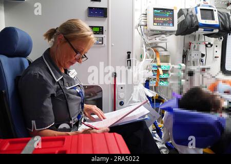 LES RÉDACTEURS NOTENT L'IMAGE PIXÉLISÉE PAR PA PICTURE DESK infirmière praticienne avancée Sarah Hardwick trie les documents administratifs d'un jeune patient transporté entre East Surrey et St. George's Hospitals dans une ambulance opérée par des ambulanciers paramédicaux du South Thames Retrieval Service (STRS), un service de soins intensifs, transportant des enfants et des jeunes gravement malades des hôpitaux locaux aux unités de soins intensifs et de soins intensifs pédiatriques de la région de la Tamise, par le biais d'ambulances spécialement équipées. Date de la photo: Vendredi 16 juin 2023. Banque D'Images