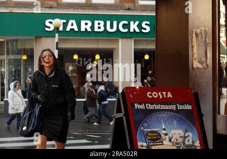 Photo du dossier datée du 03/12/2012 d'une vue de Starbucks Coffee de l'autre côté de la route de la marque rivale Costa Coffee à Nottingham. Une enquête a révélé que les cafés glacés des chaînes de rue élevées peuvent contenir plus de sucre qu'une barre de Mars ou une boîte de Coca-Cola. Lequel ? Comparé les fritpes et les frappuccinos de Caffe Nero, Costa et Starbucks pour trouver beaucoup avaient des quantités de sucre "exceptionnellement élevées". L'une des options les plus saines était un frappuccino au caramel Starbucks avec du lait demi-écrémé contenant 48,5g de sucre, soit 12 cuillères à café. Date de publication : samedi 1 juillet 2023. Banque D'Images