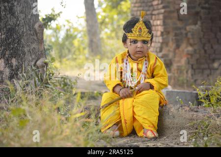 TIKAMGARH, MADHYA PRADESH, INDE - 27 AVRIL 2022 : un mignon garçon indien habillé dans l'avatar du Seigneur Krishna. Banque D'Images