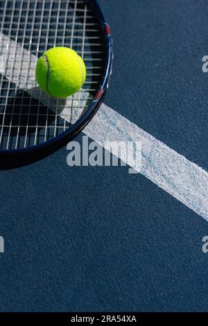 Gros plan de balle de tennis et raquette de tennis couché sur le court de tennis par jour ensoleillé, espace de copie Banque D'Images