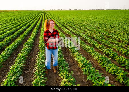 Portrait d'une agricultrice qui cultive du soja. Elle est satisfaite de la bonne progression des plantes. Occupation agricole. Banque D'Images