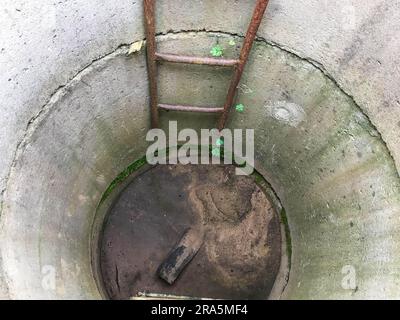 maison bien. des anneaux de béton sont installés dans la cour de la maison pour extraire des ressources du sol. mousse pousse à l'intérieur et il y a un rouillé Banque D'Images