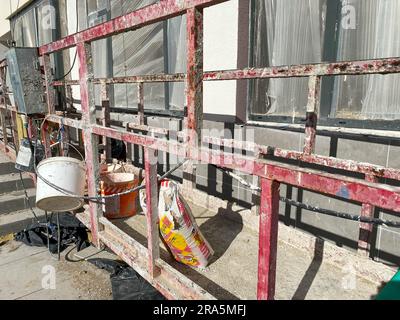 Vue sur la façade d'un nouveau bâtiment de plusieurs étages en construction. Berceau suspendu sur la façade du gratte-ciel. Plate-forme mobile d'échafaudage pour Banque D'Images