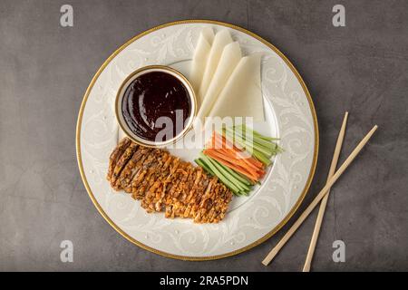 Tranches de canard de Pékin avec sauce Hoysin et concombre frais, oignon vert, carotte. Servi avec des crêpes chinoises de blé Banque D'Images