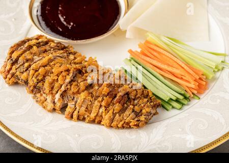 Tranches de canard de Pékin avec sauce Hoysin et concombre frais, oignon vert, carotte. Servi avec des crêpes chinoises de blé Banque D'Images