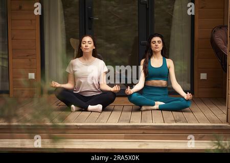 Les femmes qui font de l'exercice de yoga dans la cour Banque D'Images