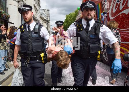 Londres, Royaume-Uni. 1st juillet 2023. Des policiers arrêtent des manifestants. Les activistes de Just Stop Oil de la communauté LGBTQ ont pulvérisé de la peinture rose et bloqué la parade de la fierté à Londres en s'asseyant devant un camion Coca-Cola prenant part à la parade, en signe de protestation contre la fierté travaillant avec des industries liées à la crise climatique et en signe de protestation contre Coca-Cola, considéré comme le plus grand pollueur de plastique au monde. Credit: Vuk Valcic/Alamy Live News Banque D'Images