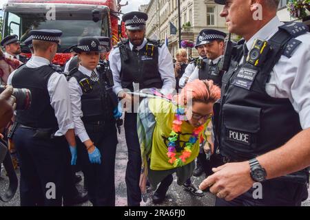 Londres, Royaume-Uni. 1st juillet 2023. Des policiers arrêtent des manifestants. Les activistes de Just Stop Oil de la communauté LGBTQ ont pulvérisé de la peinture rose et bloqué la parade de la fierté à Londres en s'asseyant devant un camion Coca-Cola prenant part à la parade, en signe de protestation contre la fierté travaillant avec des industries liées à la crise climatique et en signe de protestation contre Coca-Cola, considéré comme le plus grand pollueur de plastique au monde. Credit: Vuk Valcic/Alamy Live News Banque D'Images