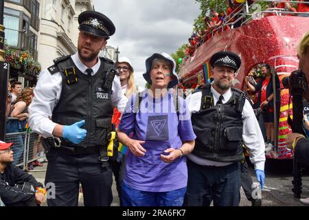 Londres, Royaume-Uni. 1st juillet 2023. Des policiers arrêtent des manifestants. Les activistes de Just Stop Oil de la communauté LGBTQ ont pulvérisé de la peinture rose et bloqué la parade de la fierté à Londres en s'asseyant devant un camion Coca-Cola prenant part à la parade, en signe de protestation contre la fierté travaillant avec des industries liées à la crise climatique et en signe de protestation contre Coca-Cola, considéré comme le plus grand pollueur de plastique au monde. Credit: Vuk Valcic/Alamy Live News Banque D'Images