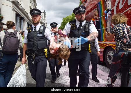 Londres, Royaume-Uni. 1st juillet 2023. Des policiers arrêtent des manifestants. Les activistes de Just Stop Oil de la communauté LGBTQ ont pulvérisé de la peinture rose et bloqué la parade de la fierté à Londres en s'asseyant devant un camion Coca-Cola prenant part à la parade, en signe de protestation contre la fierté travaillant avec des industries liées à la crise climatique et en signe de protestation contre Coca-Cola, considéré comme le plus grand pollueur de plastique au monde. Credit: Vuk Valcic/Alamy Live News Banque D'Images