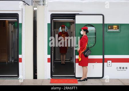 (230701) -- XINING, 1 juillet 2023 (Xinhua) -- les préposés du train à grande vitesse Fuxing C891 sur la section Xining-Golmud du chemin de fer Qinghai-Tibet attendent les passagers à Xining, dans la province de Qinghai, au nord-ouest de la Chine, à 1 juillet 2023. Samedi, les trains à grande vitesse Fuxing ont officiellement commencé à fonctionner dans la section Xining-Golmud du chemin de fer Qinghai-Tibet. Avec une longueur totale d'exploitation de 829 km, il part de Xining, capitale de la province de Qinghai, dans le nord-ouest de la Chine, à l'est et passe par Huangyuan, Haiyan, Ulan, Delingha à la gare de Golmud dans l'ouest, selon China Railway Qingha Banque D'Images