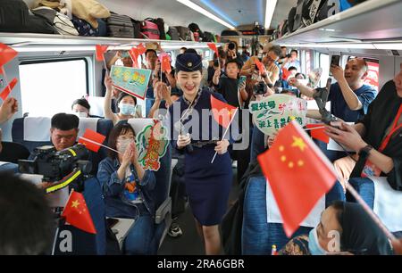 (230701) -- XINING, 1 juillet 2023 (Xinhua) -- un accompagnateur interagit avec les passagers du train à grande vitesse Fuxing C891 sur la section Xining-Golmud du chemin de fer Qinghai-Tibet sur 1 juillet 2023. Samedi, les trains à grande vitesse Fuxing ont officiellement commencé à fonctionner dans la section Xining-Golmud du chemin de fer Qinghai-Tibet. Avec une longueur totale d'exploitation de 829 km, il part de Xining, capitale de la province de Qinghai, dans le nord-ouest de la Chine, à l'est et passe par Huangyuan, Haiyan, Ulan, Delingha à la gare de Golmud à l'ouest, selon China Railway Qinghai-Tibet Group Co., Ltd (Photo de Ha Banque D'Images