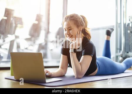 femme en bonne santé profiter de l'intervalle relax frein à la salle de fitness club de sport en utilisant ordinateur portable regardant le contenu en ligne. Banque D'Images