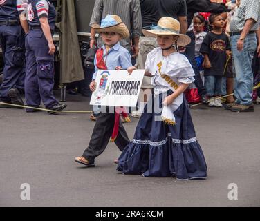 Jeune garçon et fille en robe traditionnelle tenant un signe de leur ville d'origine dans un défilé de la Journée de l'indépendance du Costa Rica à San José. Banque D'Images