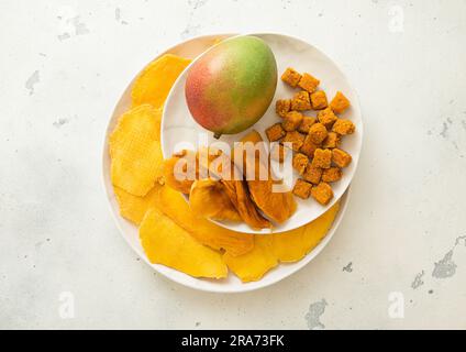 Assiettes avec tranches de mangue sucrées séchées et boules de mangue juteuse fraîche. Banque D'Images